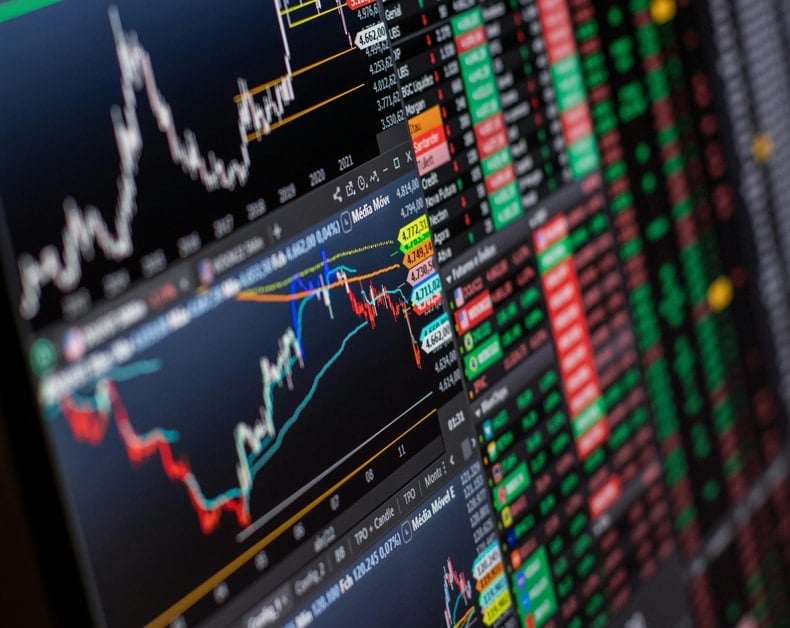 Trading dashboard showing candlestick charts, price lines, and a color-coded table of stock quotes on the right side.