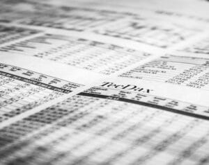 Close-up of a newspaper page featuring the TechDay masthead and stock quotes accessible to readers evaluating financial info in print.
