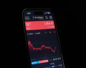 Smartphone screen showing stock app with SET index at 1,454.47 in a red banner and a red-line chart below.