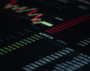 Close-up of a dark stock trading screen with green and red numbers and a central 4,092.54.