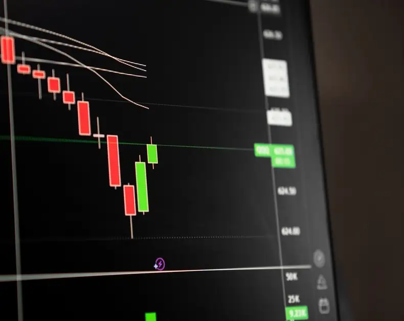 Candlestick stock chart on a dark trading interface, showing red and green candles and price lines.